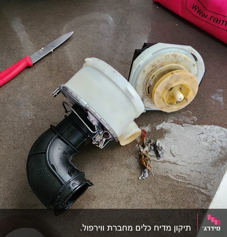 משאבת מים מפורקת עם צינור שחור על משטח